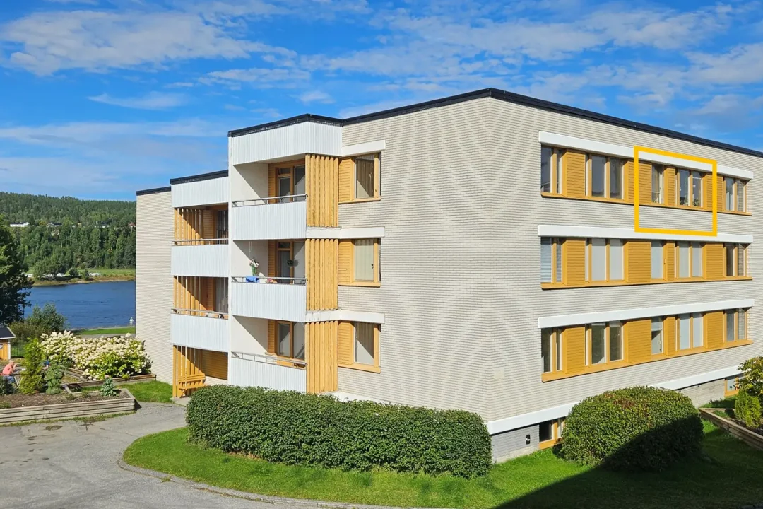 Ledig lägenhet i Sollefteå med 1 rum och kokvrå på Djupövägen 23 A, byggnaden från sydväst med Ångermanälven i bakgrunden