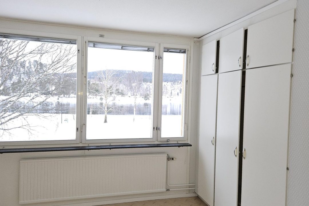Sovrum med stora fönster mot Ångermanälven och ny tapet på Djupövägen 17 i centrala Sollefteå